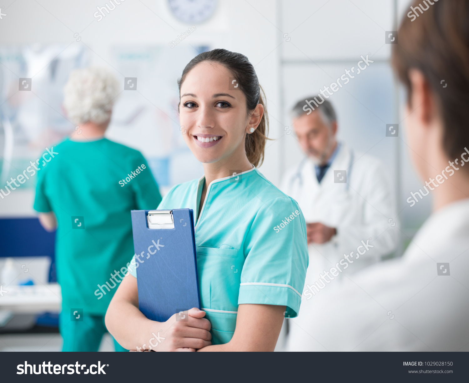 Young female medical student working at the hospital and medical staff, she is holding medical records #1029028150
