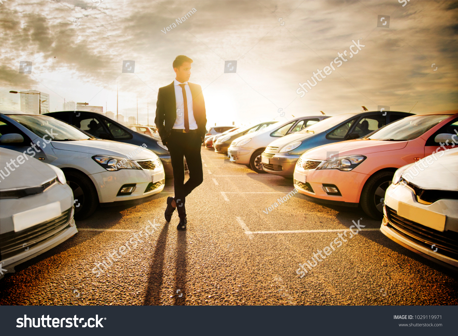 Handsome young man in a business suit choosing a car in the car market #1029119971