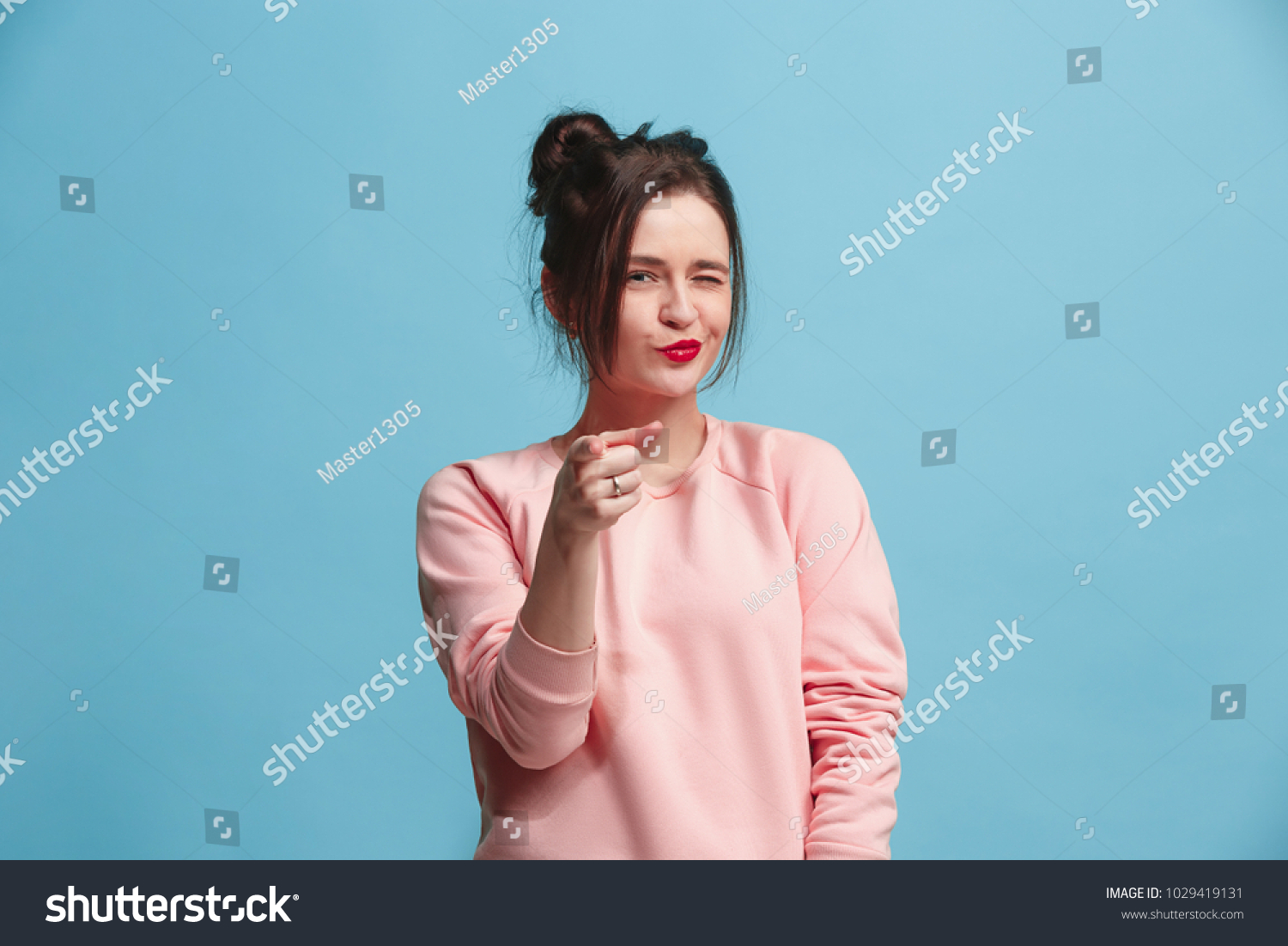 I choose you and order. The smiling business woman point you, want you, half length closeup portrait on blue studio background. The human emotions, facial expression concept. Front view. Trendy colors #1029419131
