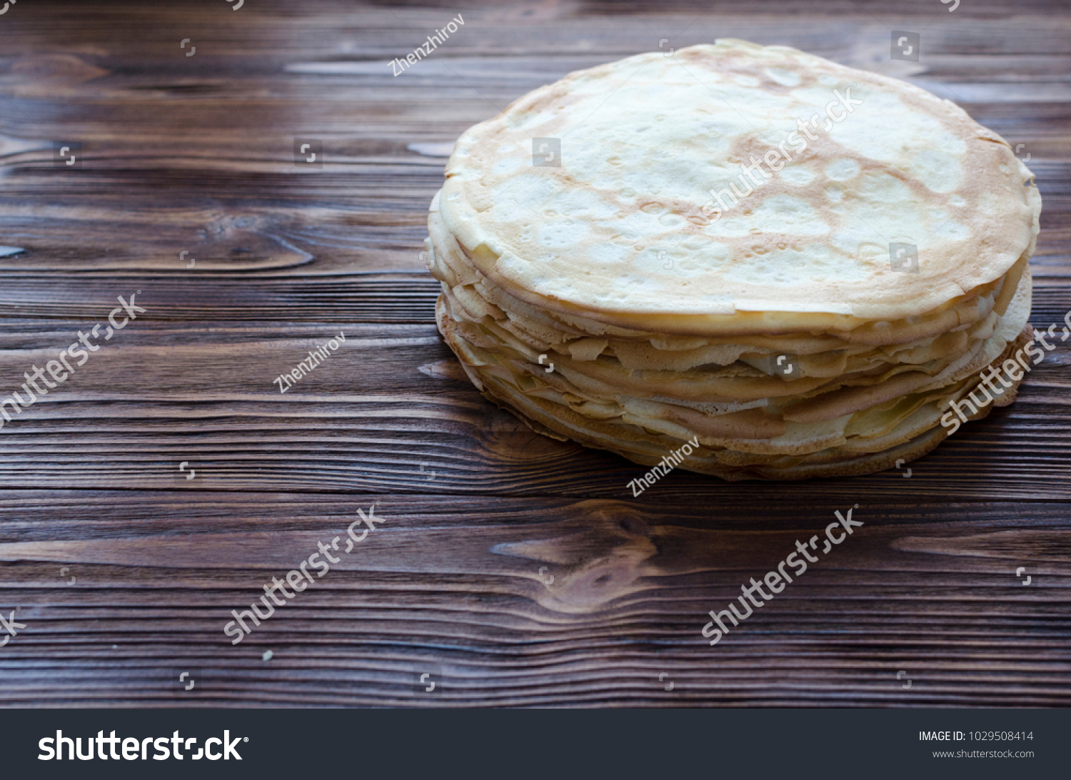 pile of pancakes on wooden background #1029508414