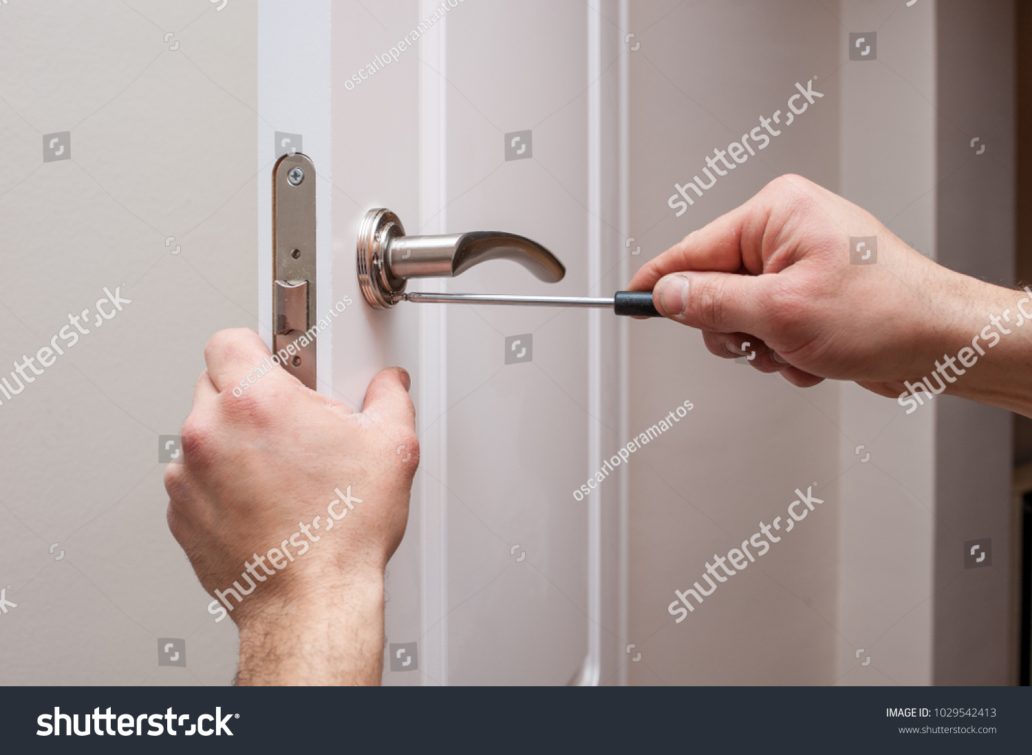man screwing with a screwdriver at home #1029542413