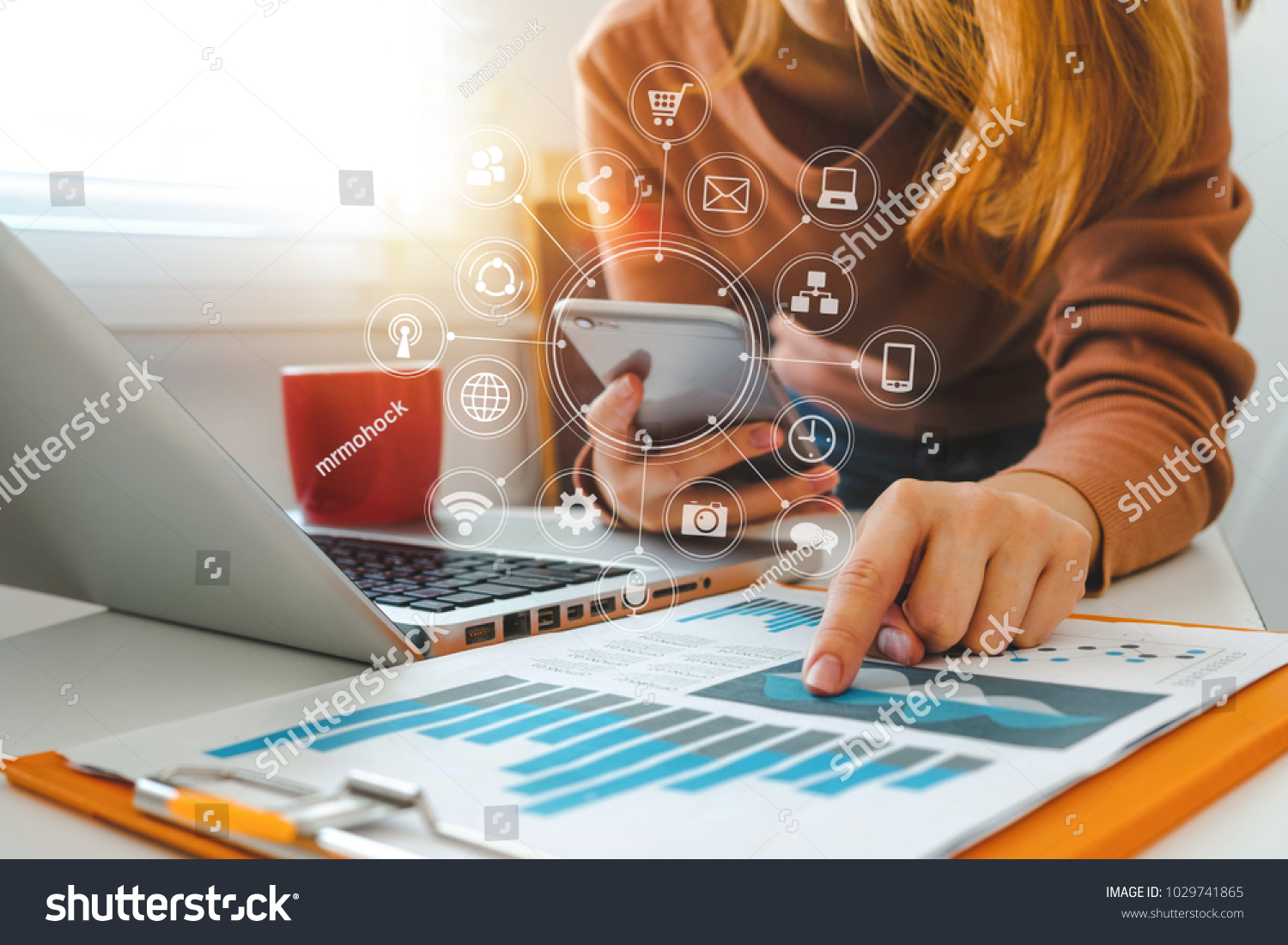 close up of businesswoman working with smart phone and laptop and digital tablet computer in modern office with virtual icon diagram #1029741865