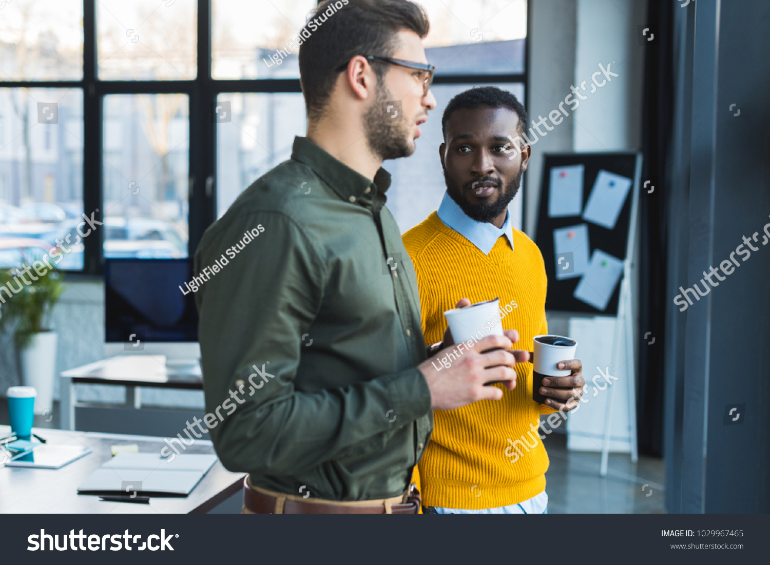 multicultural businessmen talking and holding cups of coffee #1029967465
