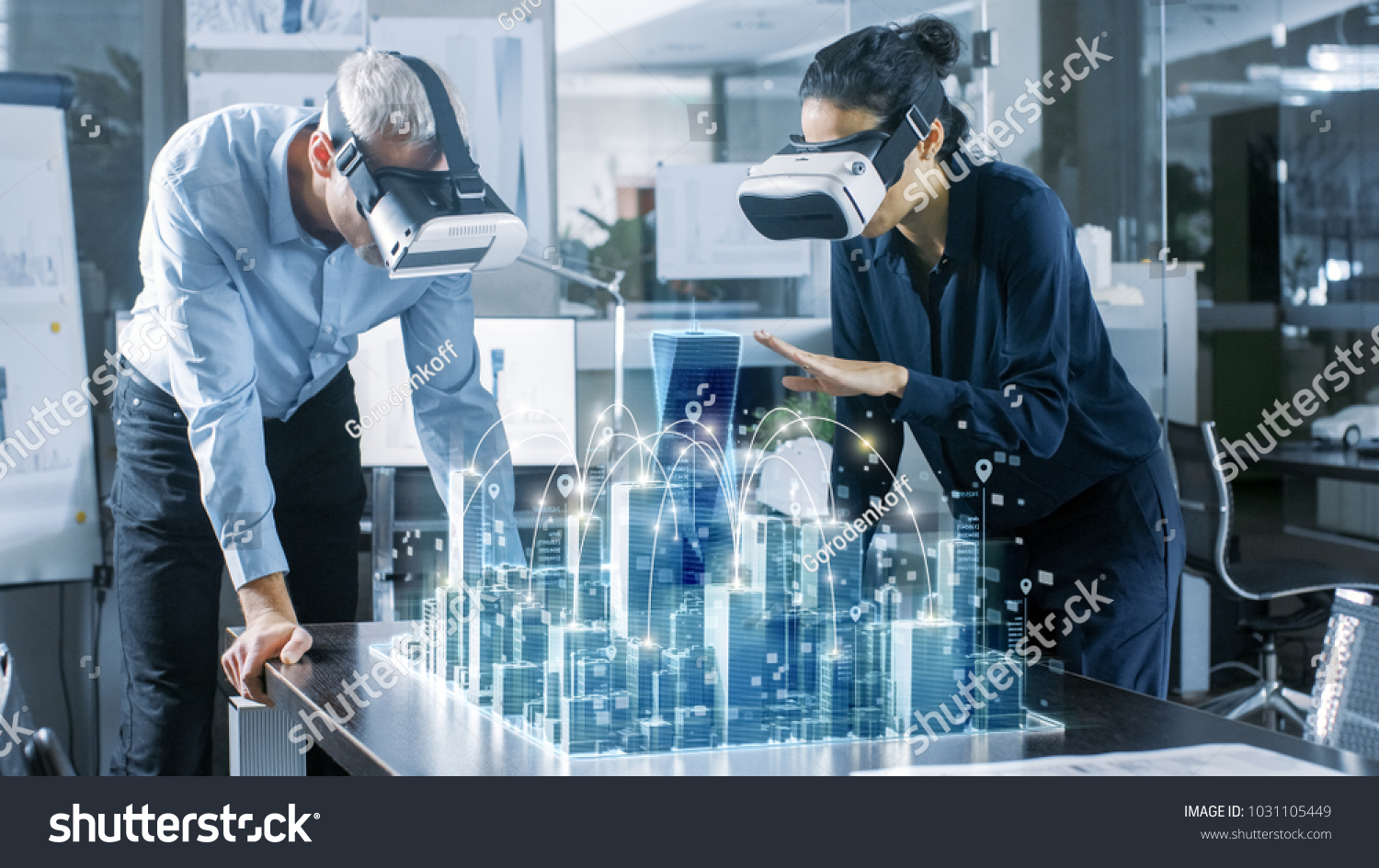 Male and Female Architects Wearing  Augmented Reality Headsets Work with 3D City Model. High Tech Office Professional People Use Virtual Reality Modeling Software Application. #1031105449