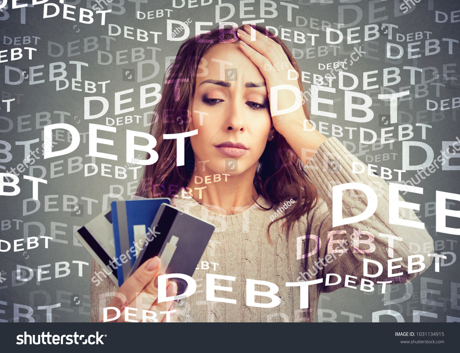 Concerned woman looking at many credit cards scared with huge amount of debt. #1031134915
