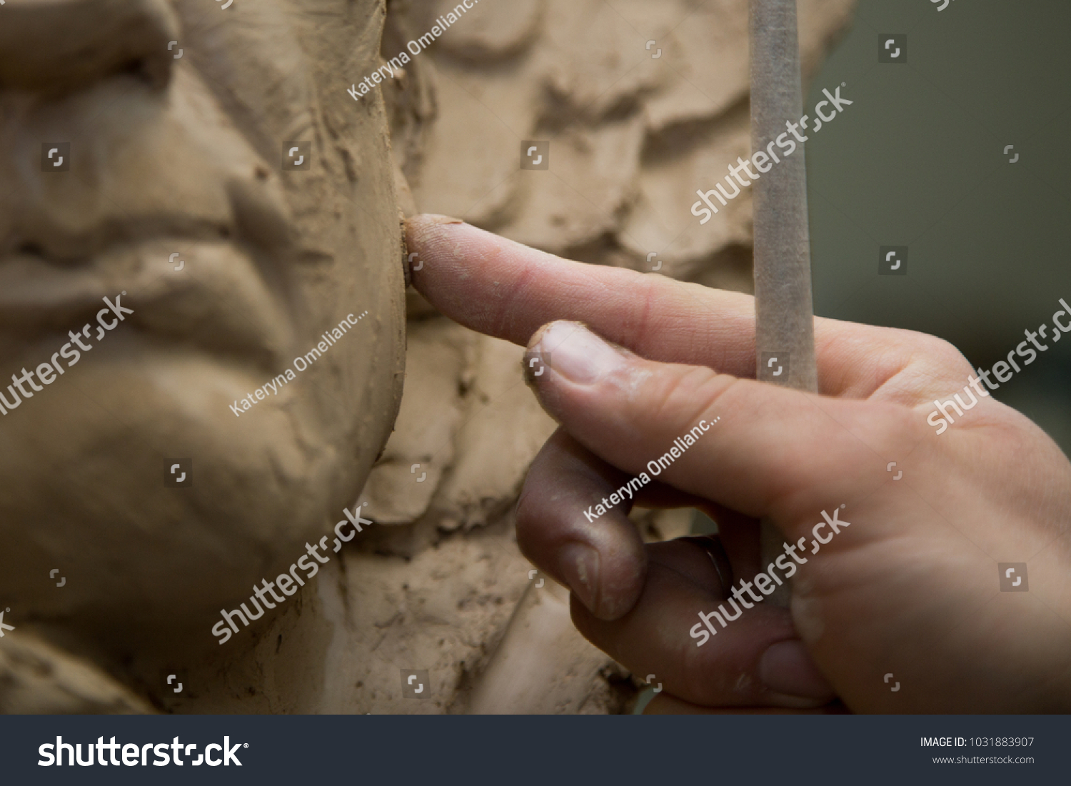 Sculptor artist creating a bust sculpture with clay #1031883907