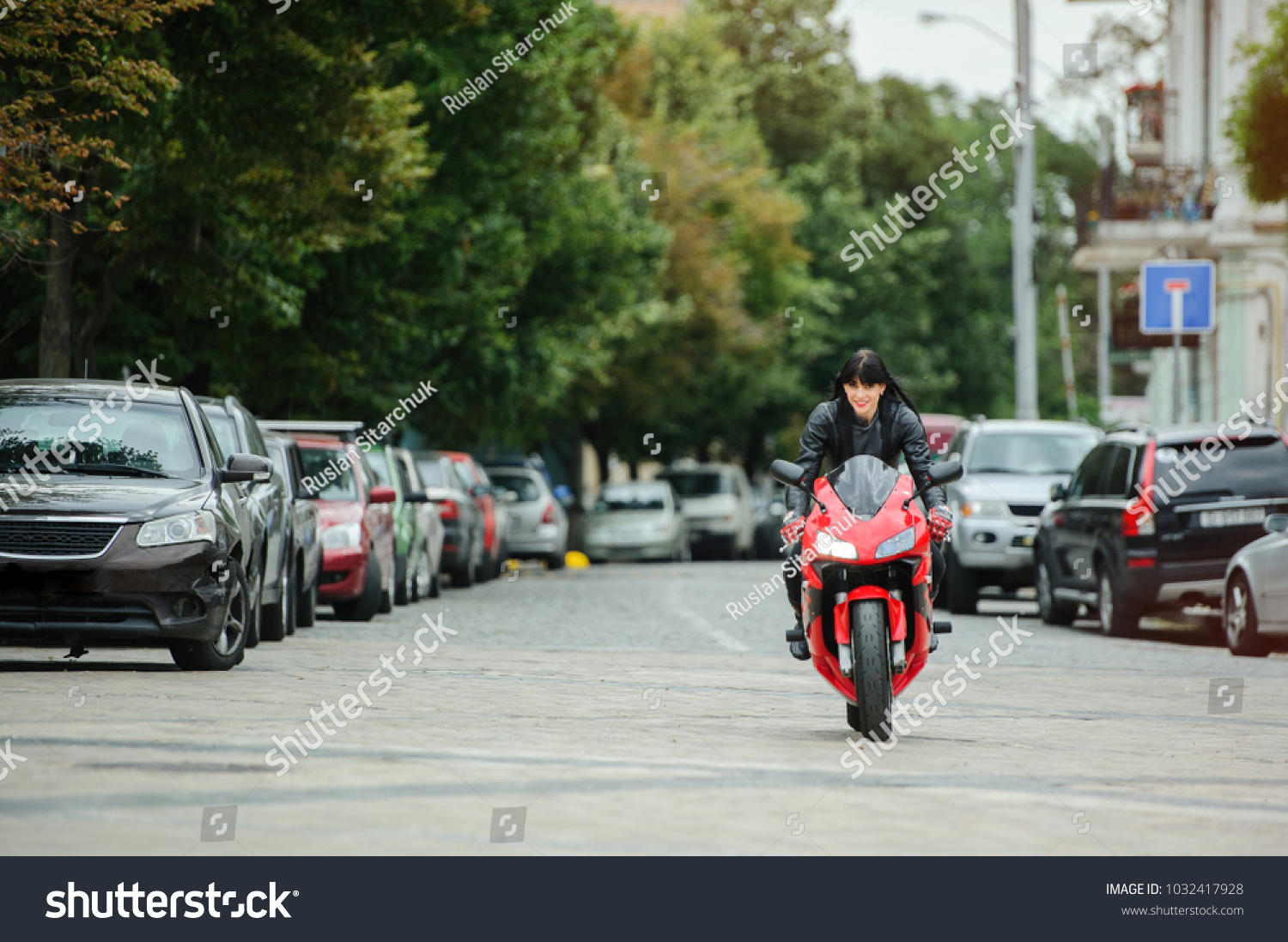 A biker girl in a leather jacket on a motorcycle rides in the city. #1032417928