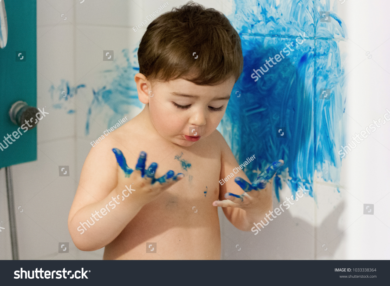 toddler.naughty child. mischievous, childhood. motherhood. five minutes of silence. the little boy draws paint. scamp a naughty boy. parenthood. mother scolds. dirty wall. stained the wall. in the bat #1033338364