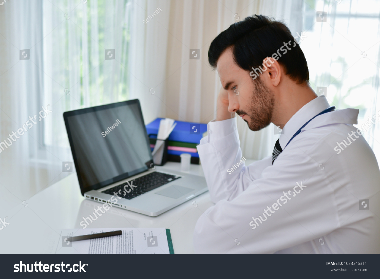 Doctor Concept. Doctors are making serious faces. The doctor is stressed about work. The doctor is feeling a headache at work. The doctor is feeling stressed in treating the patient. #1033346311