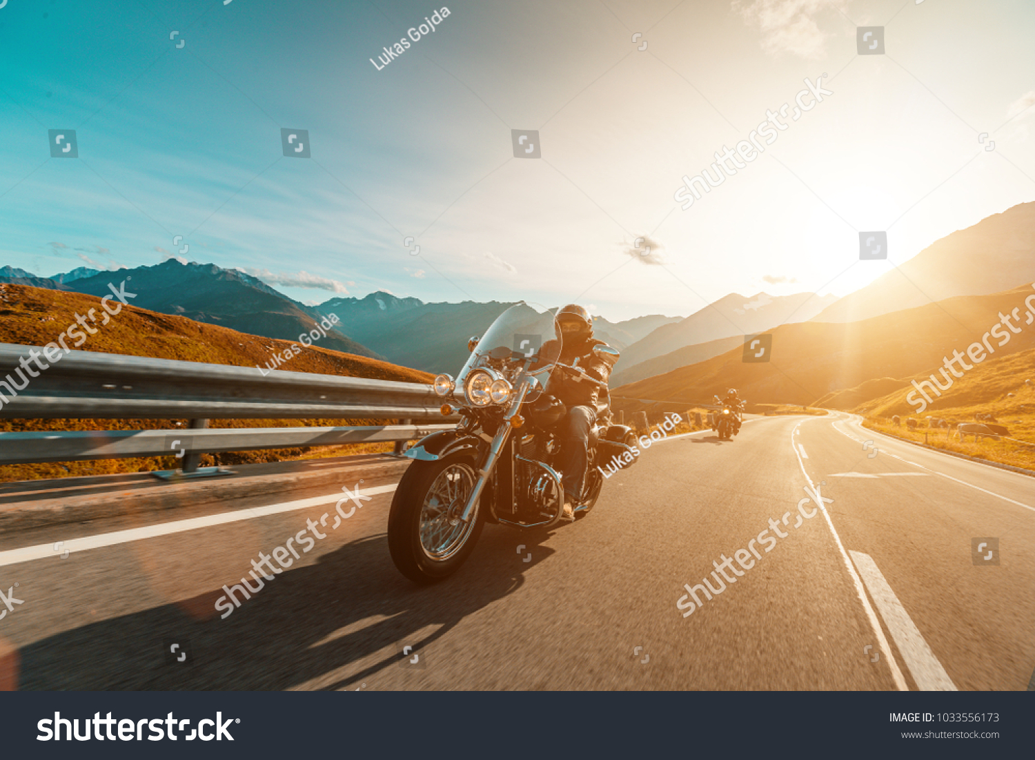 Motorcycle driver riding japanese high power cruiser in Alpine highway on famous Hochalpenstrasse, Austria, central Europe. #1033556173