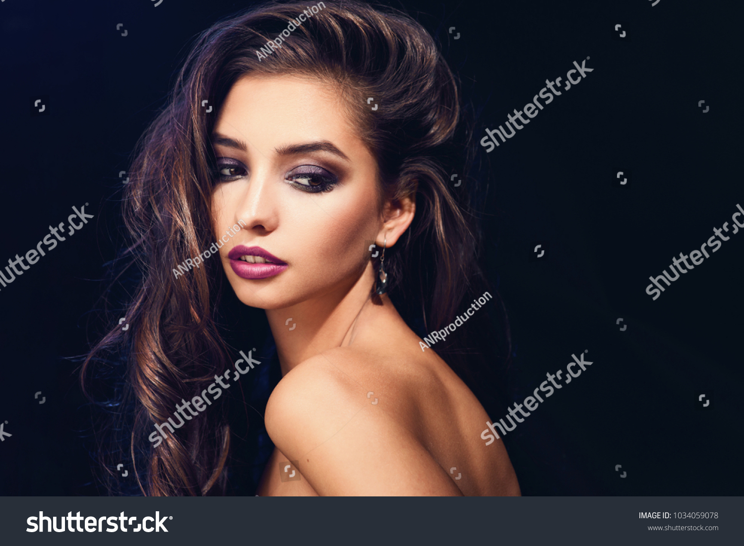 Fashion beauty trend portrait of beautiful brunette girl with long and shiny curly hair. Sexy baby faced model woman with curls hairstyle. Care and beauty of hair. Bright violet lips #1034059078