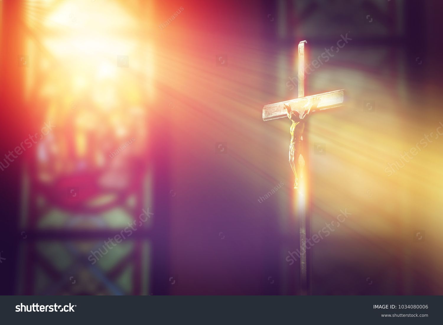 crucifix, jesus on the cross in church with ray of light from stained glass