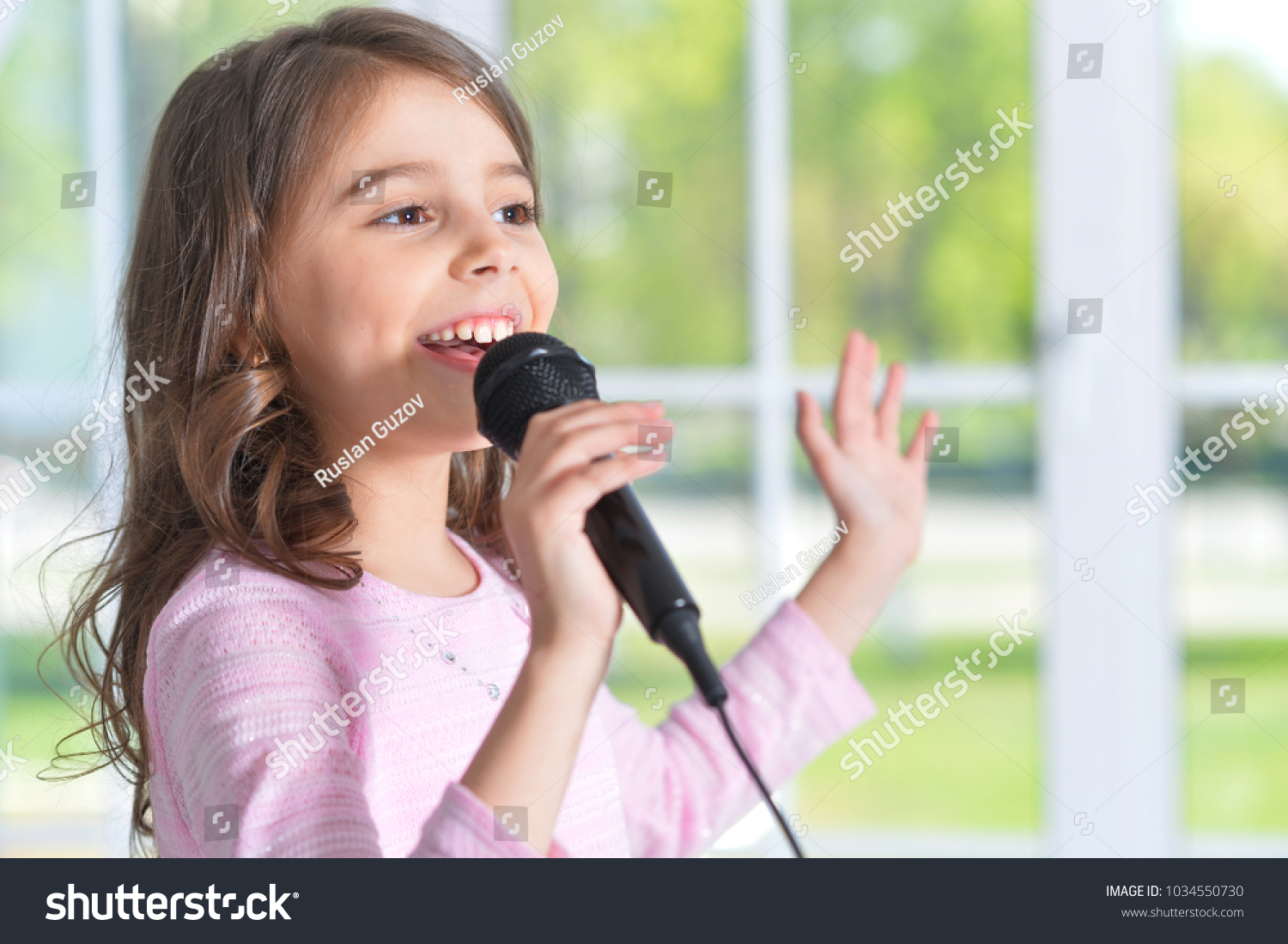 Beautiful little girl with microphone  #1034550730