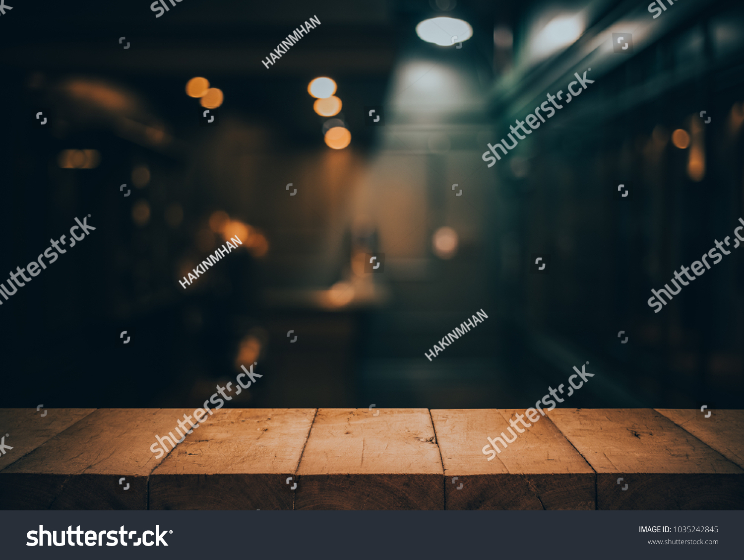 Wood table top on blurred of counter cafe shop with light bulb.Background for montage product display or design key visual layout. #1035242845