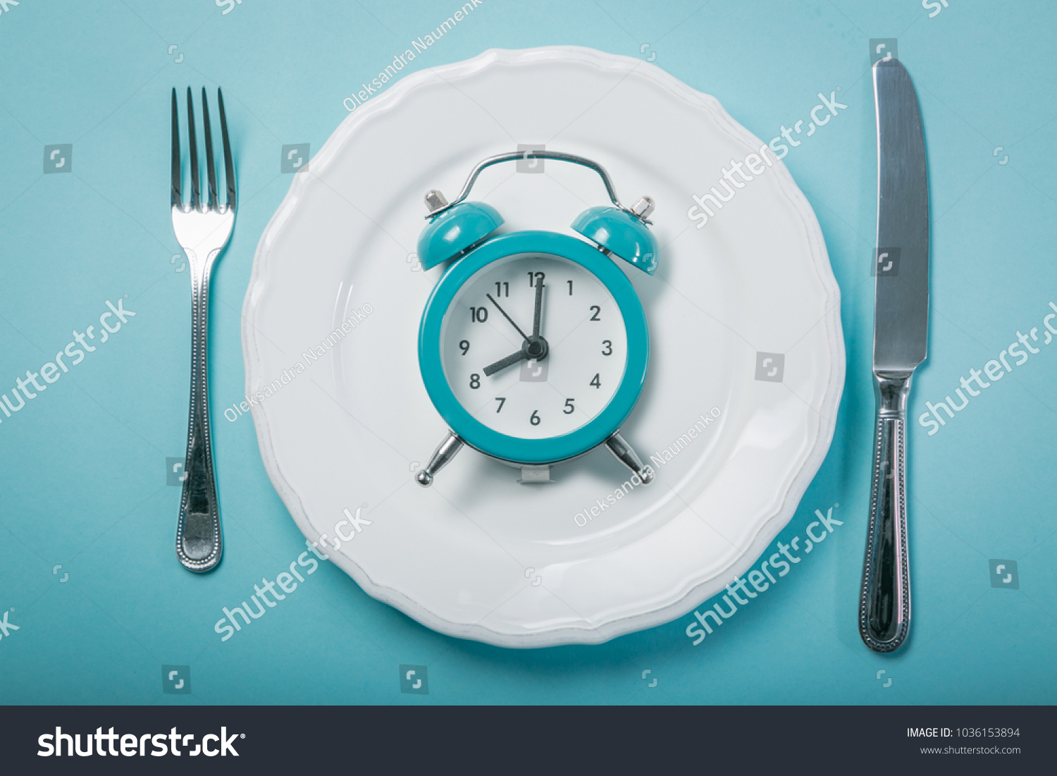 Intermittent fastin concept - empty plate on blue background #1036153894