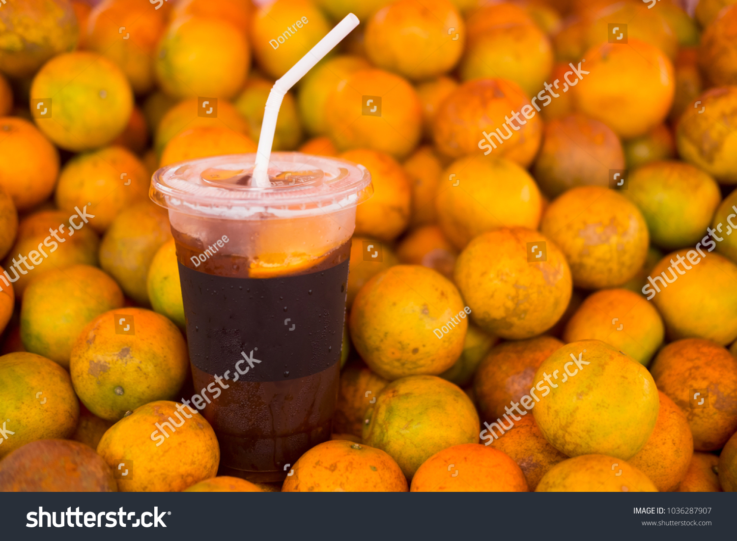 Ice coffee brew mix with orange juice on pile orange #1036287907