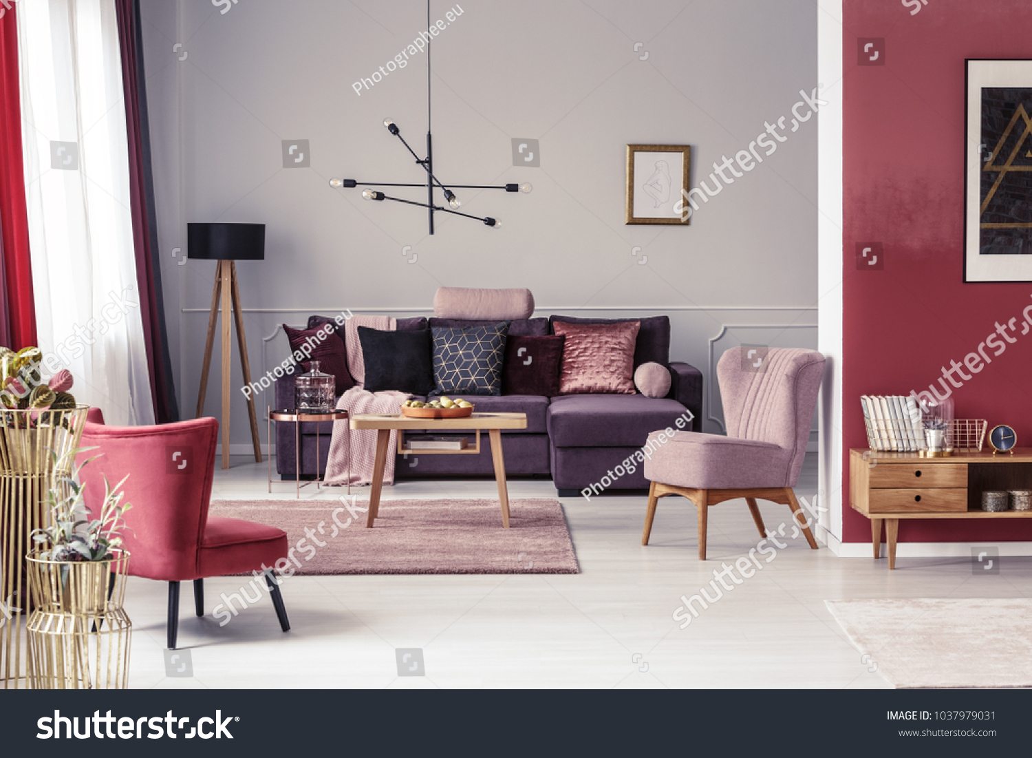 Pink and red armchair in warm living room interior with pillows on settee against the wall with poster #1037979031
