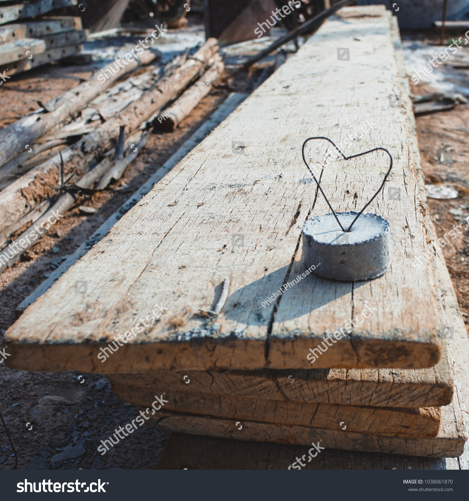 Heart created from steel wire on the concrete lump. Love symbol and sign on the wood. Abstract of love sign and symbol. #1038061870