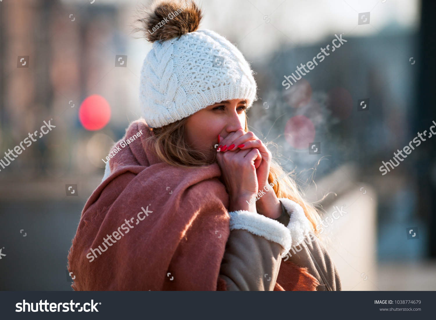 Woman breathing on her hands to keep them warm at cold winter day #1038774679
