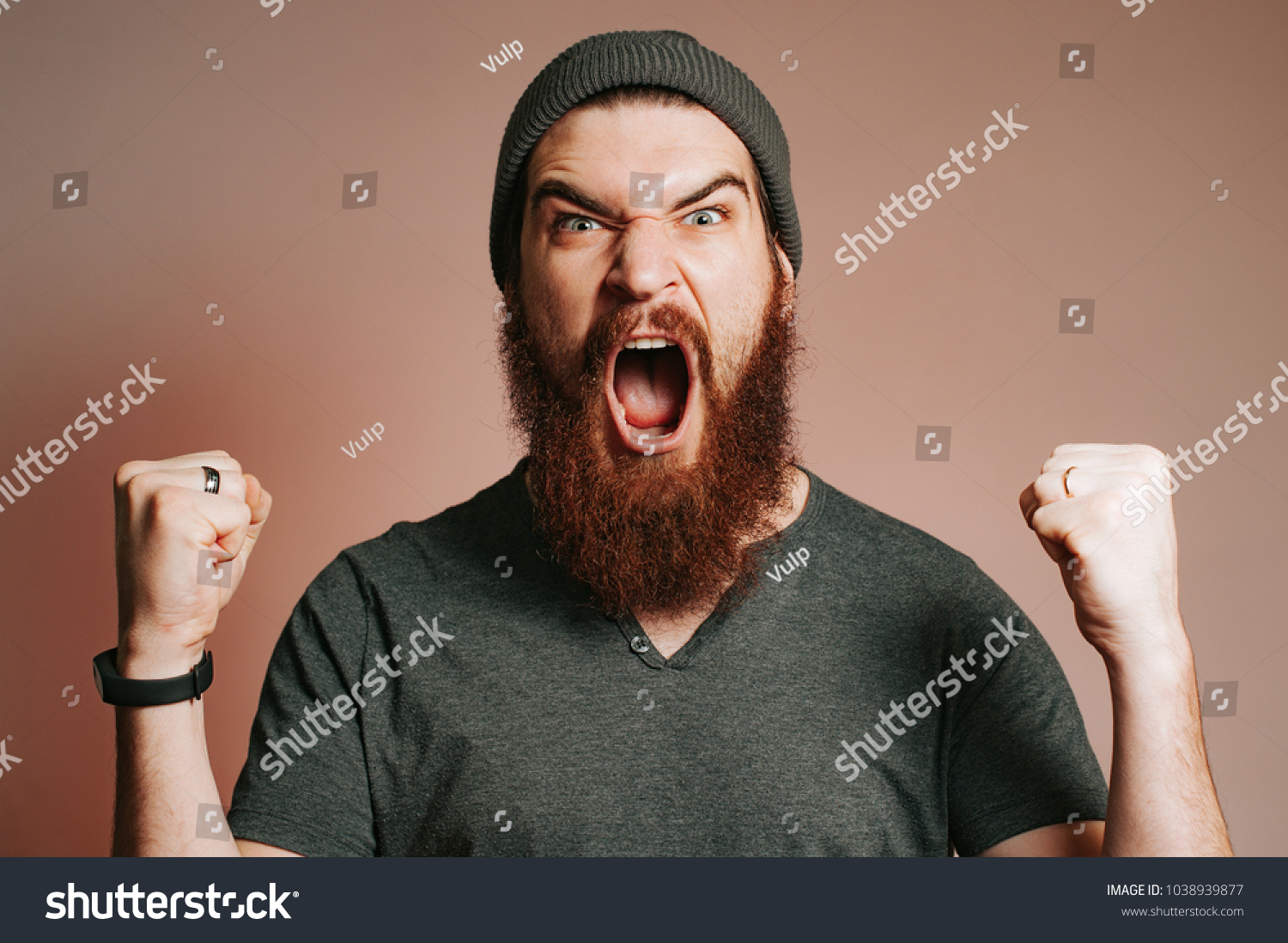 Screaming bearded brutal man and looking at the camera with hands up, Goal, Winner, Celebrating. Face expression. Crazy man with beard. #1038939877