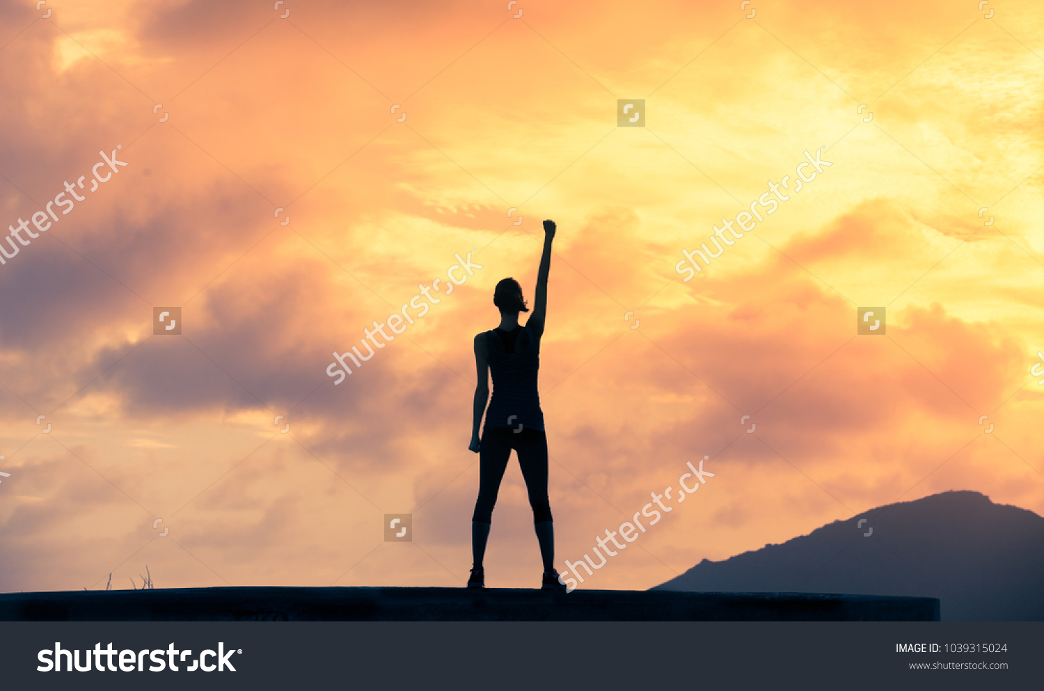 Stand strong. Woman with fist in the air. Feeling motivated, strength and courage concept.  #1039315024