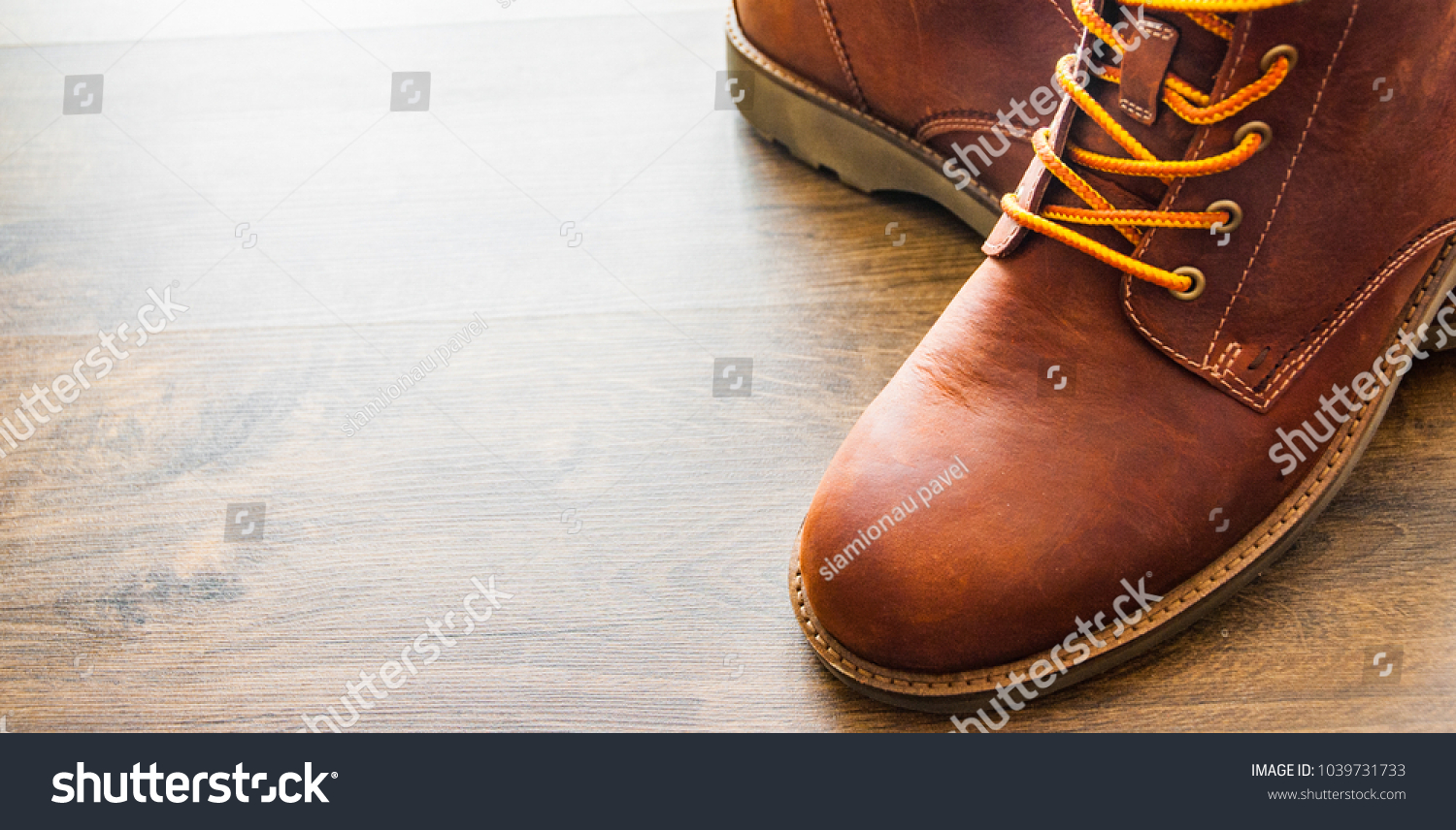 brown leather boots shoes on the brown wooden table background.with copy space. #1039731733