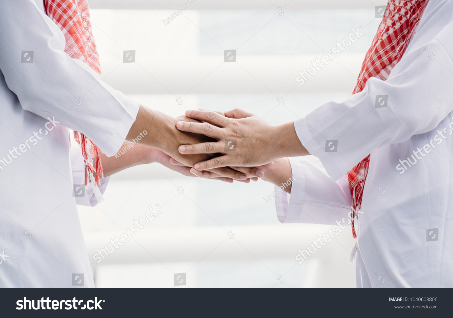 Two Arab young men are shaking hands to greet on the backdrop of a civilized city. #1040603806