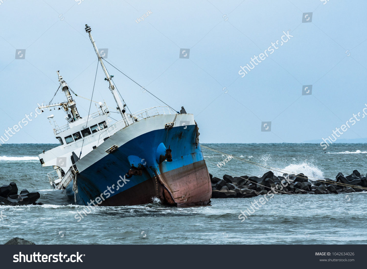 Cargo ship run aground on rocky shore #1042634026