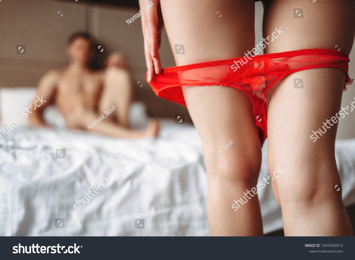 Female legs with red panties down in front of man #1043256913