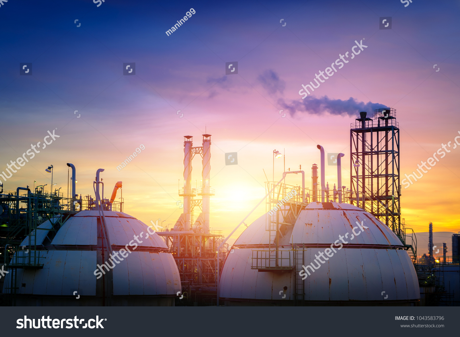 Gas storage sphere tanks with smoke stacks on sky sunset background #1043583796