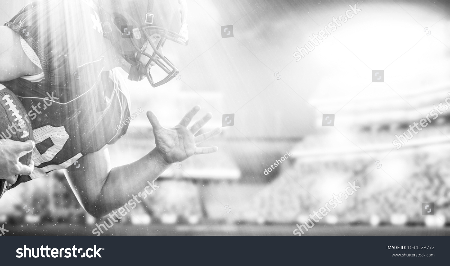 American football Player running with the ball isolated on big modern stadium field with lights and flares #1044228772