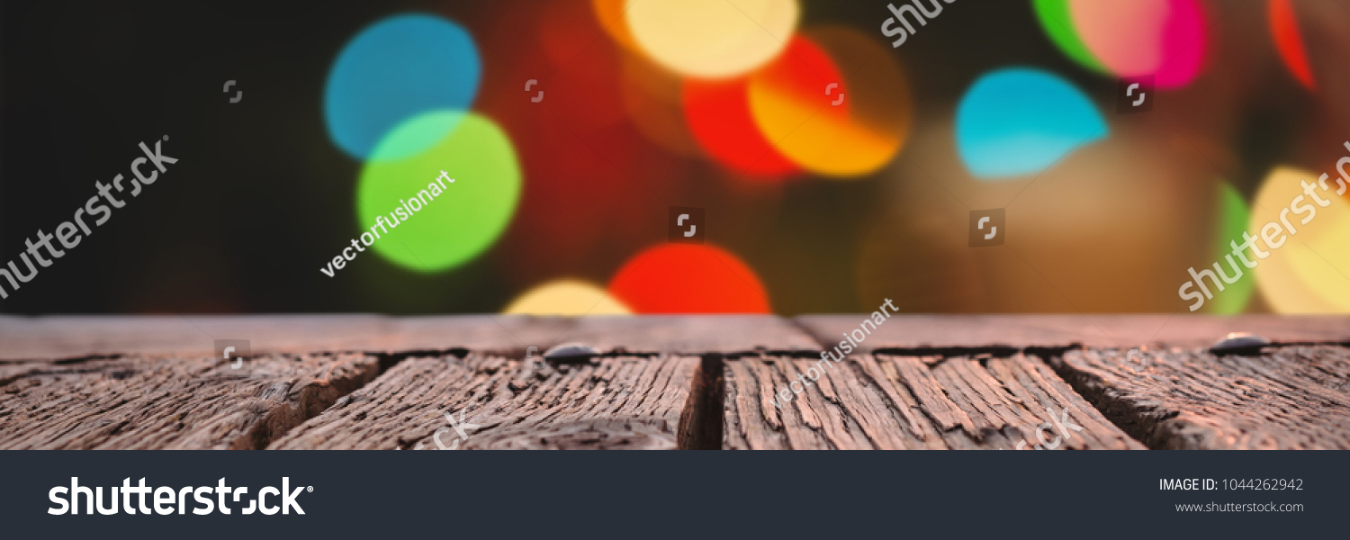 Rusty wooden plank against defocused of christmas tree lights and fireplace #1044262942