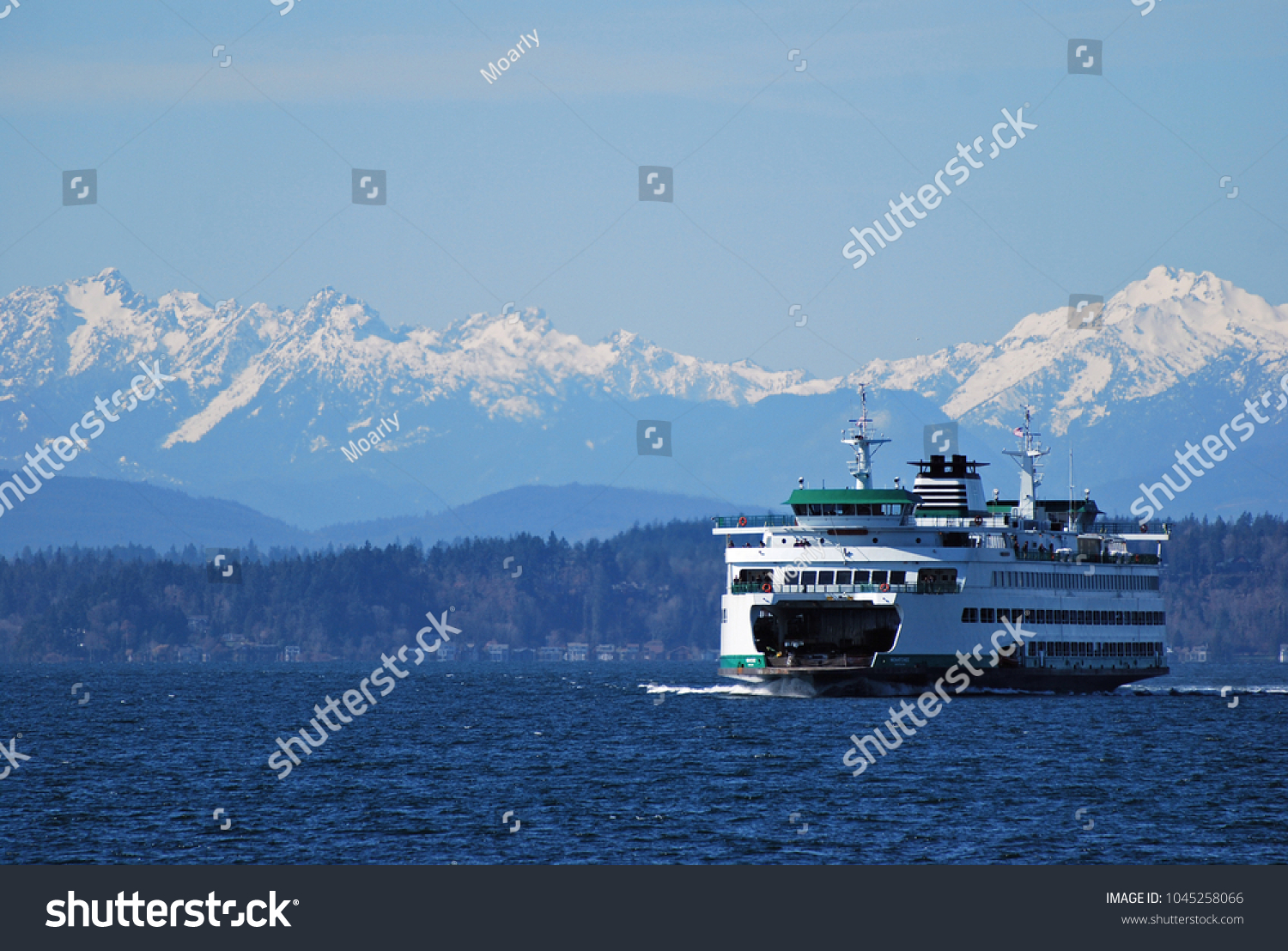 Washington State Ferry cruises in front of Olympic Mountains on approach to Seattle #1045258066