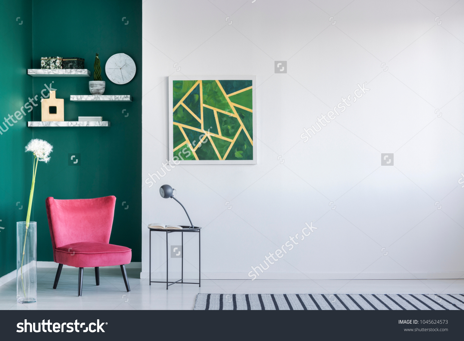 Green wall in a living room interior with pink armchair, painting, coffee table and striped rug #1045624573