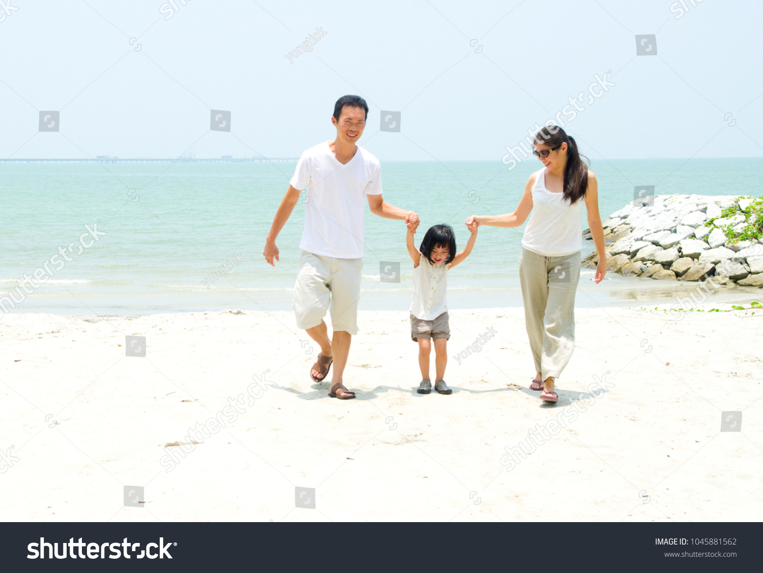 Happy family having fun at beach during summer day #1045881562