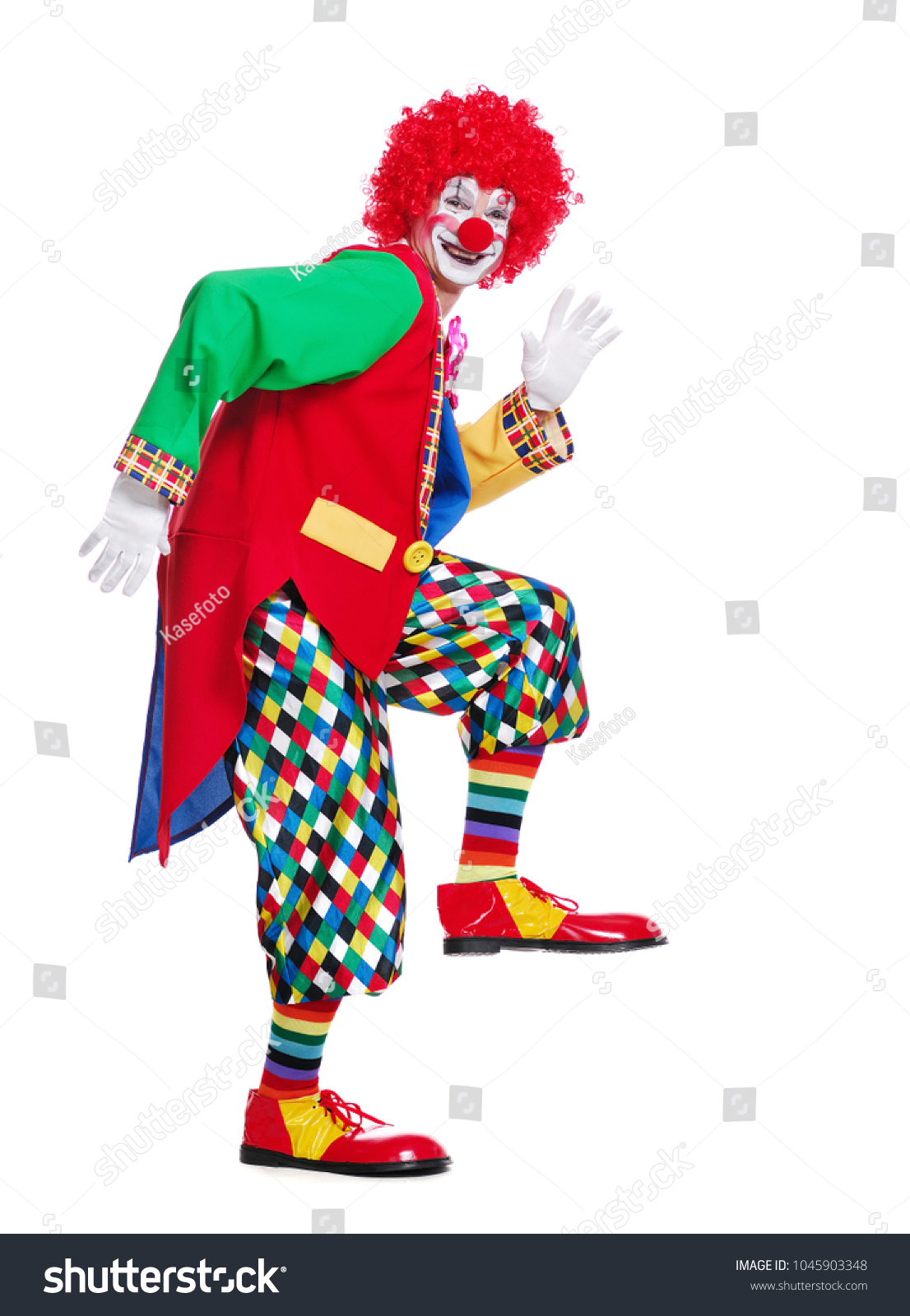 Side view full length picture of a clown imitating comic walk  #1045903348