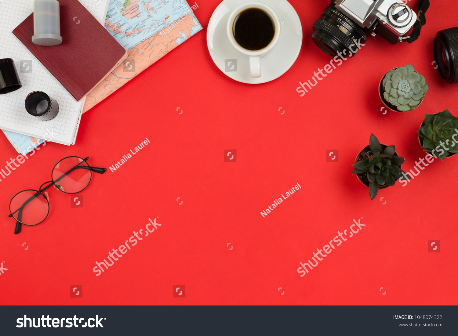 Flatlay frame arrangement with vintage film camera, lenses, glasses,  notebook, map, cup of coffee and succulents. Travel, planning or business mockup, red background, copyspace #1048074322