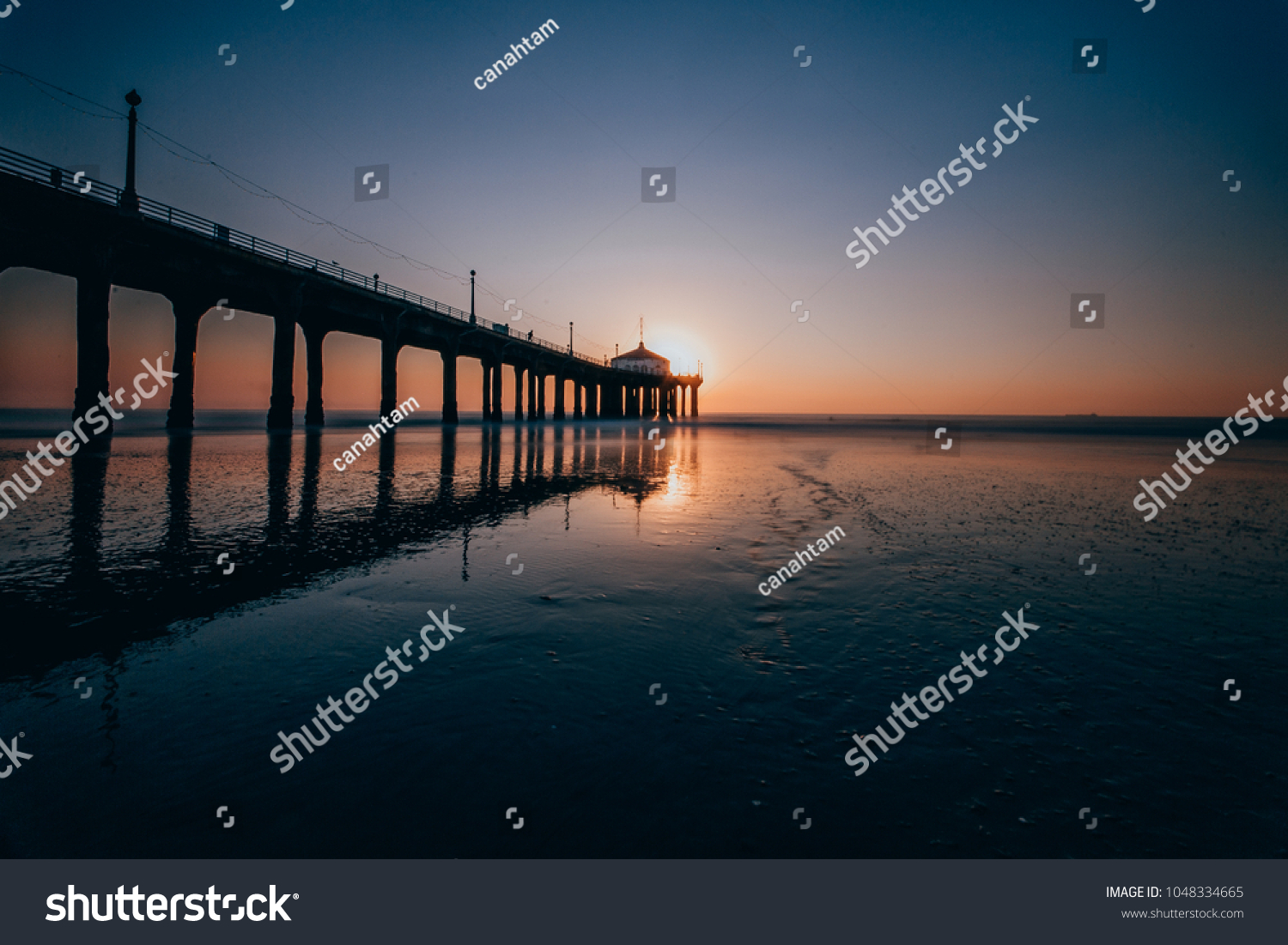 Long Exposure photo of Manhattan Beach Pier from the side with the reflective wet sand during sunset in Manhattan Beach, California #1048334665