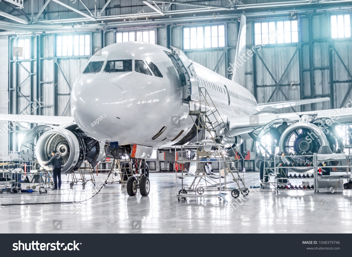 Passenger aircraft on maintenance of engine and fuselage repair in airport hangar #1048379746