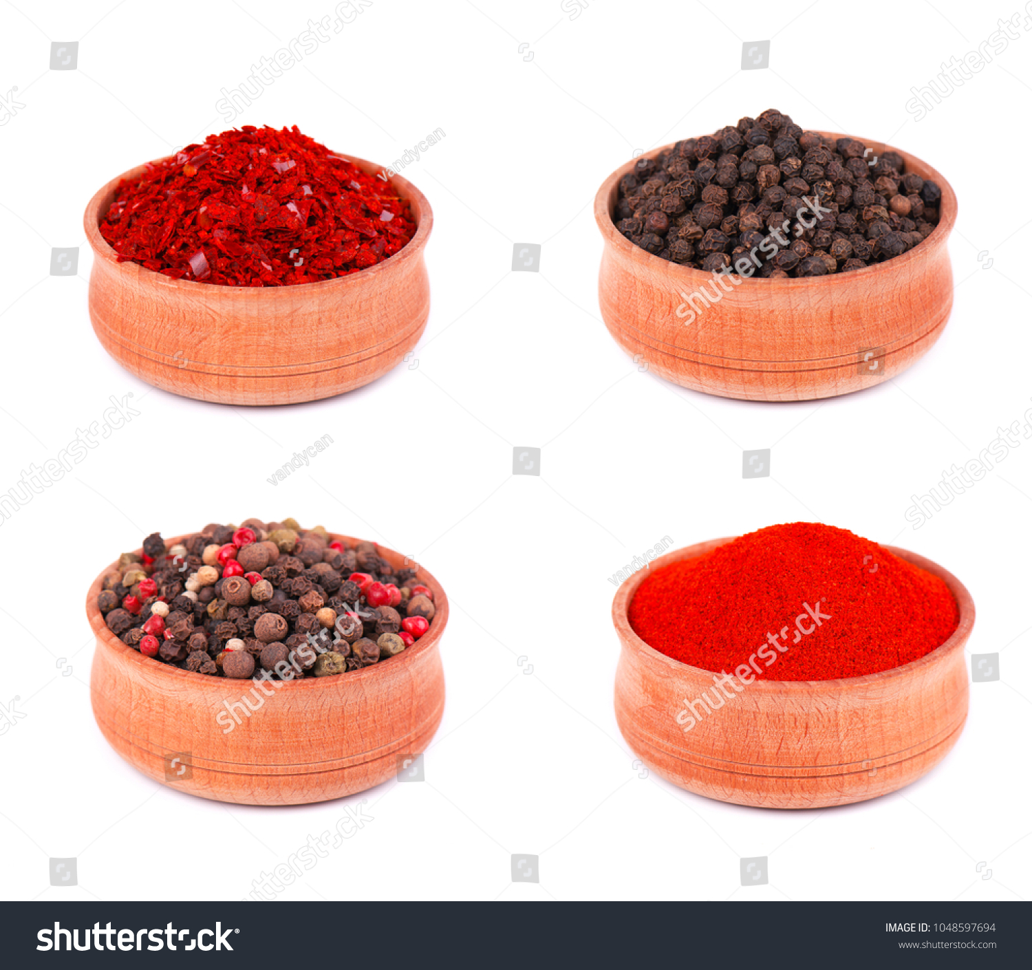 Spice selection of paprika, mixed spice, cayenne pepper, and allspice ground in wooden bowl, isolated on white background. Collage of peppers and powder on white background. #1048597694