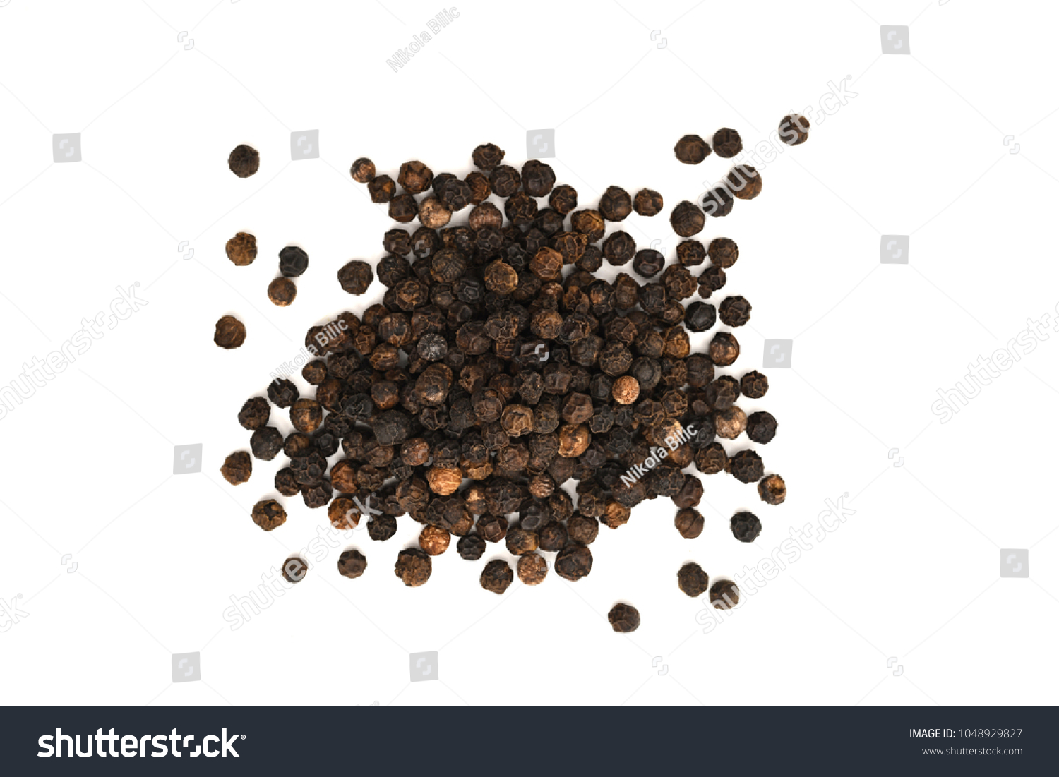 Close-up image of black pepper on white background, view above #1048929827