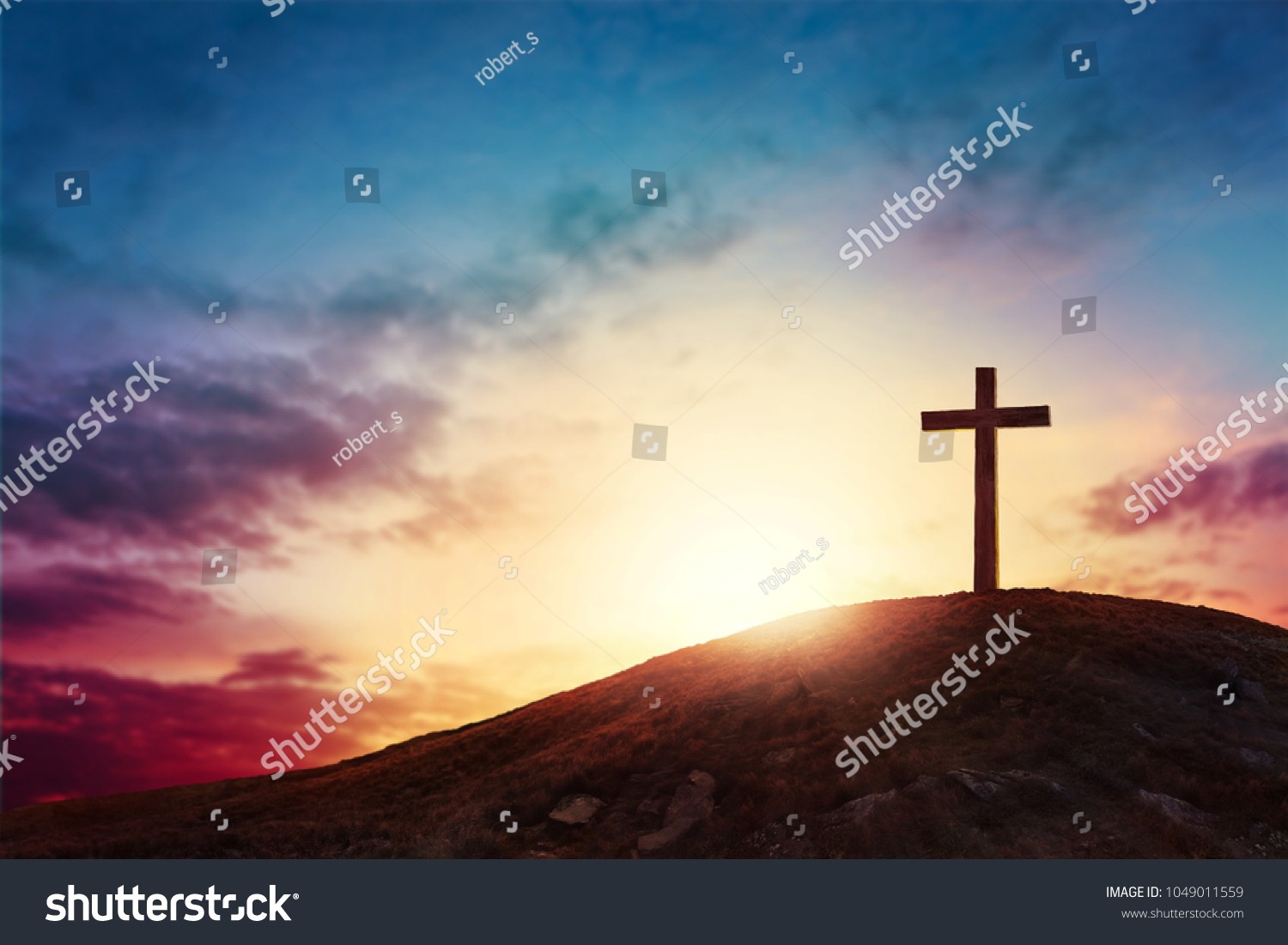 Silhouette cross on Calvary mountain sunset background. Easter concept #1049011559