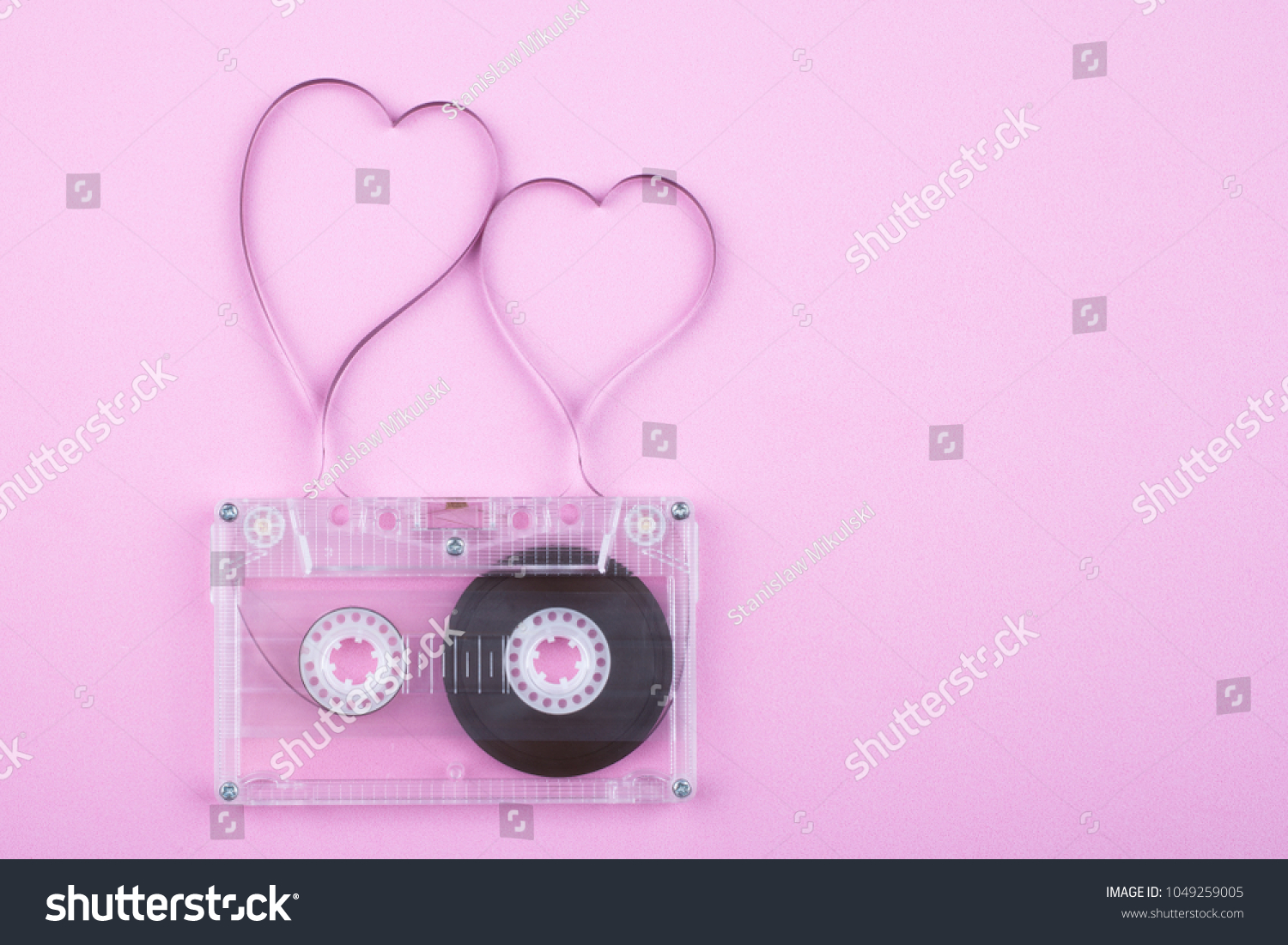 Film in a shape of heart from Compact Cassette. Love for music and songs. Pink background. #1049259005