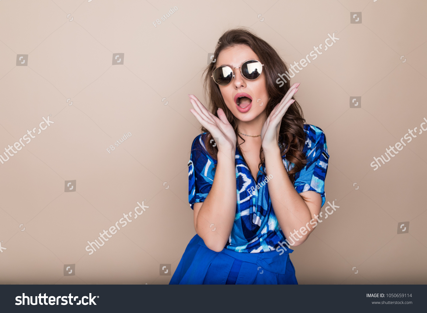Happy woman in sunglasses looking excited look at the camera on color studio background. Body language #1050659114