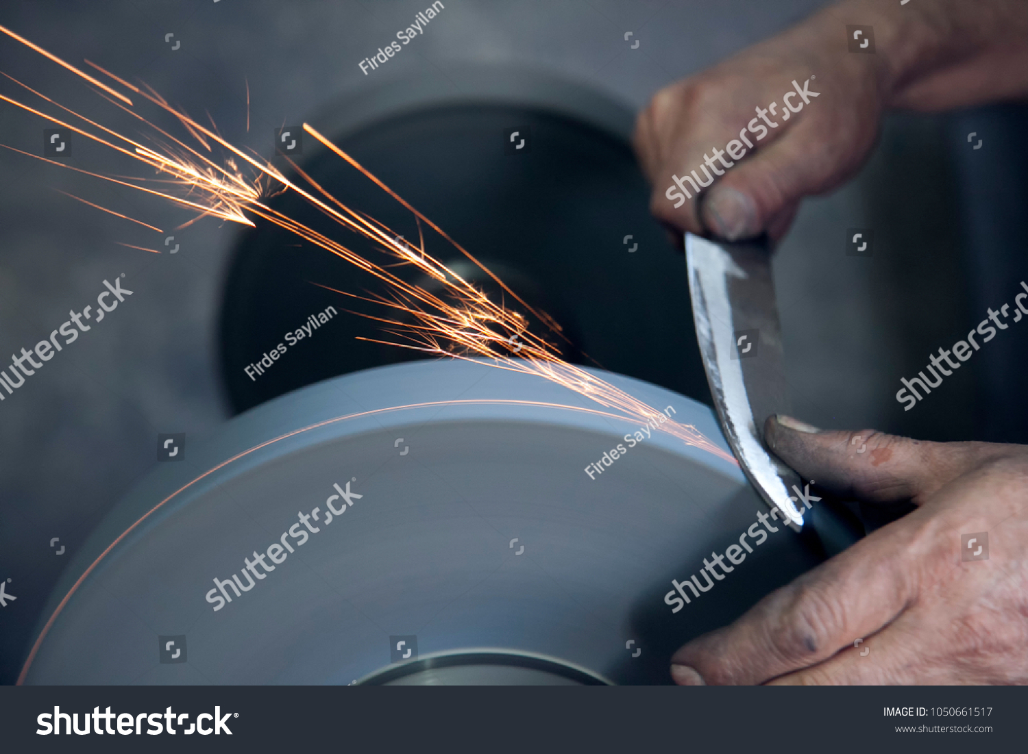 Knife sharpener and hand with blade on  table, closeup #1050661517