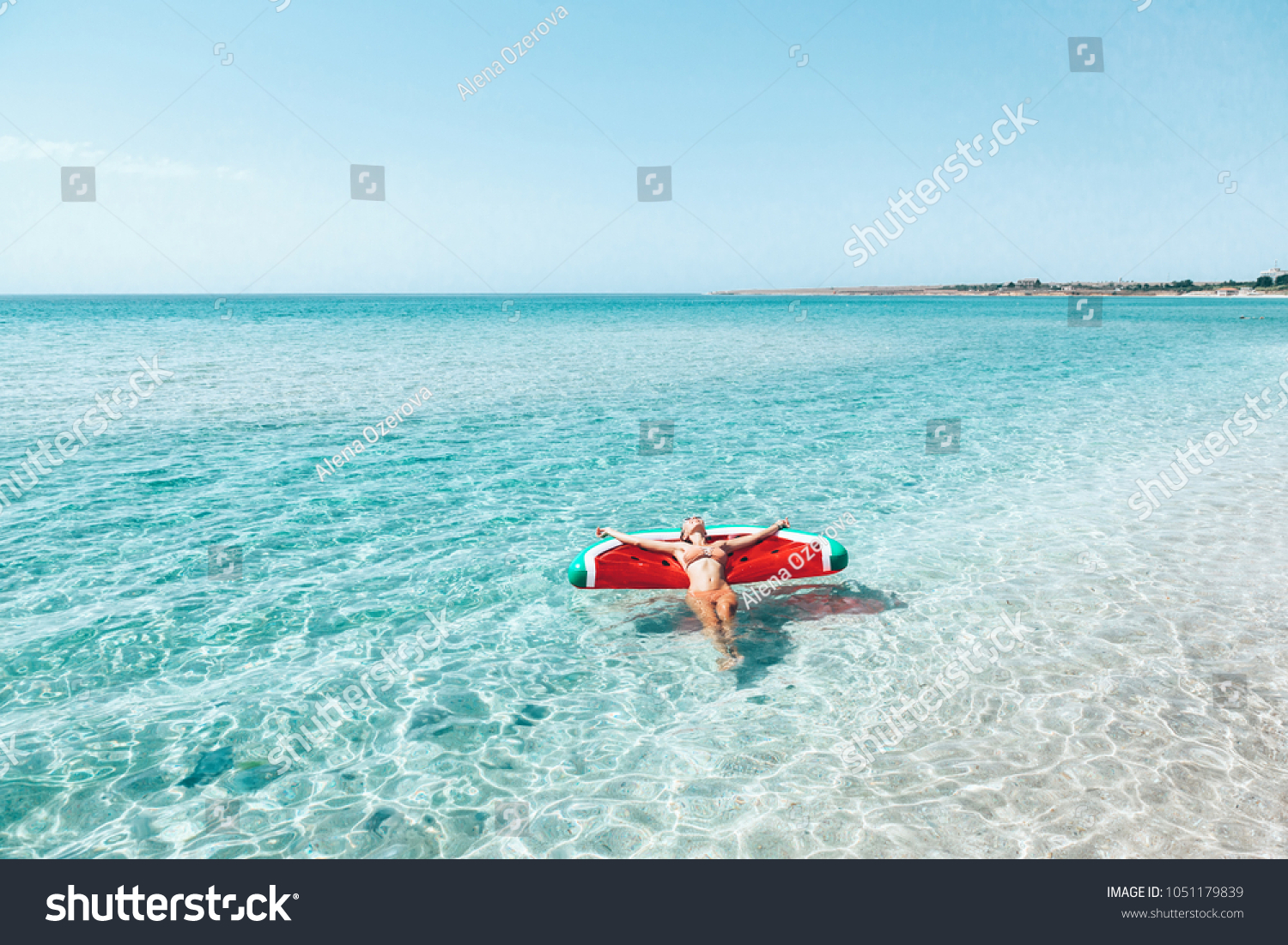 Woman on lilo in the sea water. Girl relaxing on inflatable ring on the beach. Summer vacations, idyllic scene. #1051179839