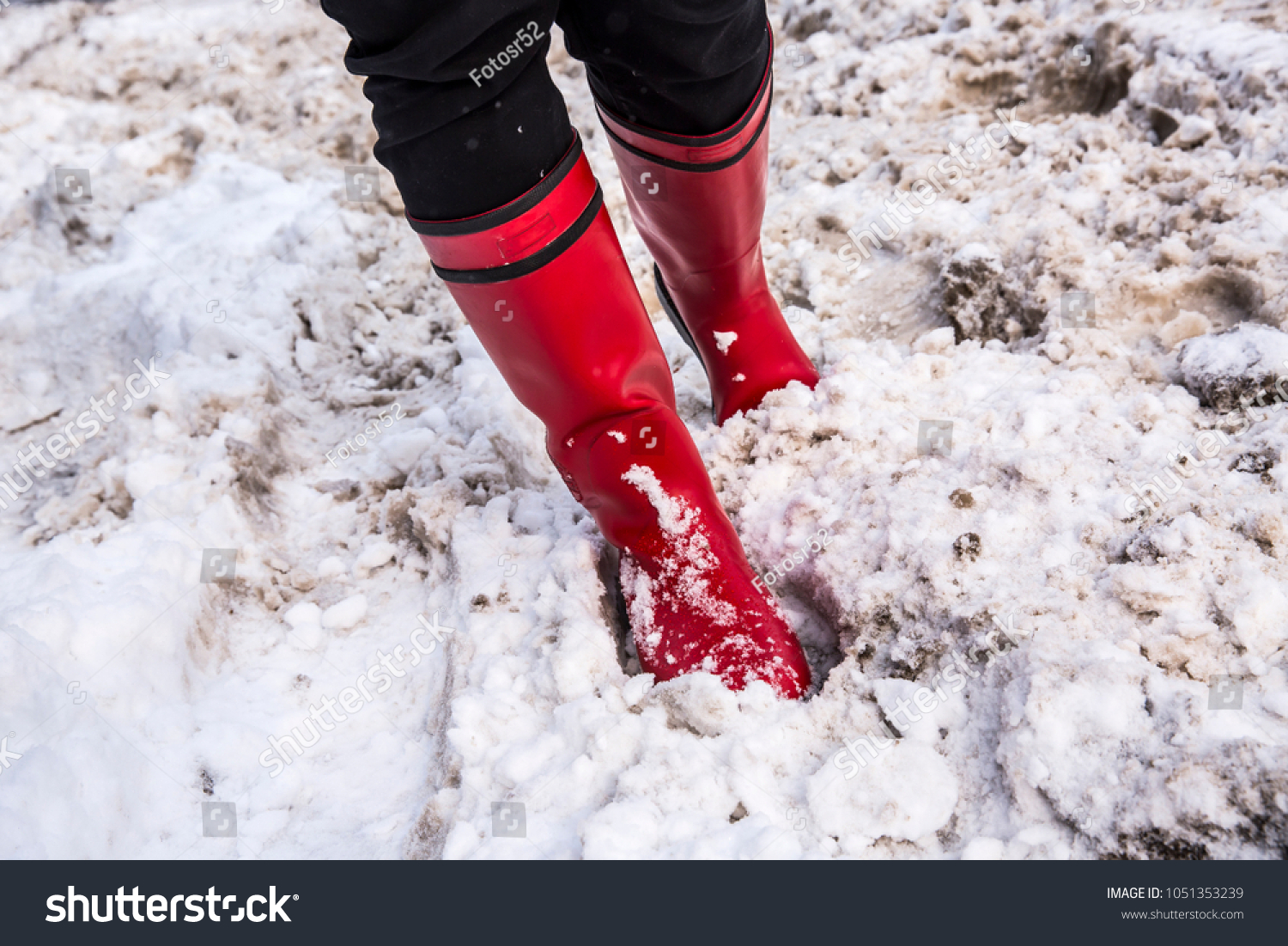Girl in red boots in deep snow. Winter concept #1051353239