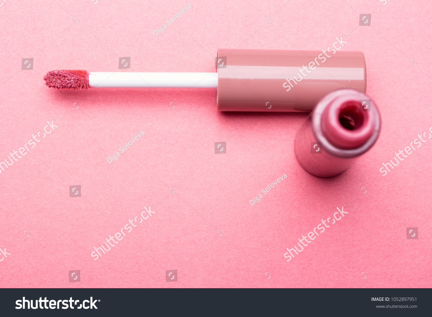Brush for make-up lips and the bottle of liquid lipstick close-up on a pink background with copyspace #1052897951