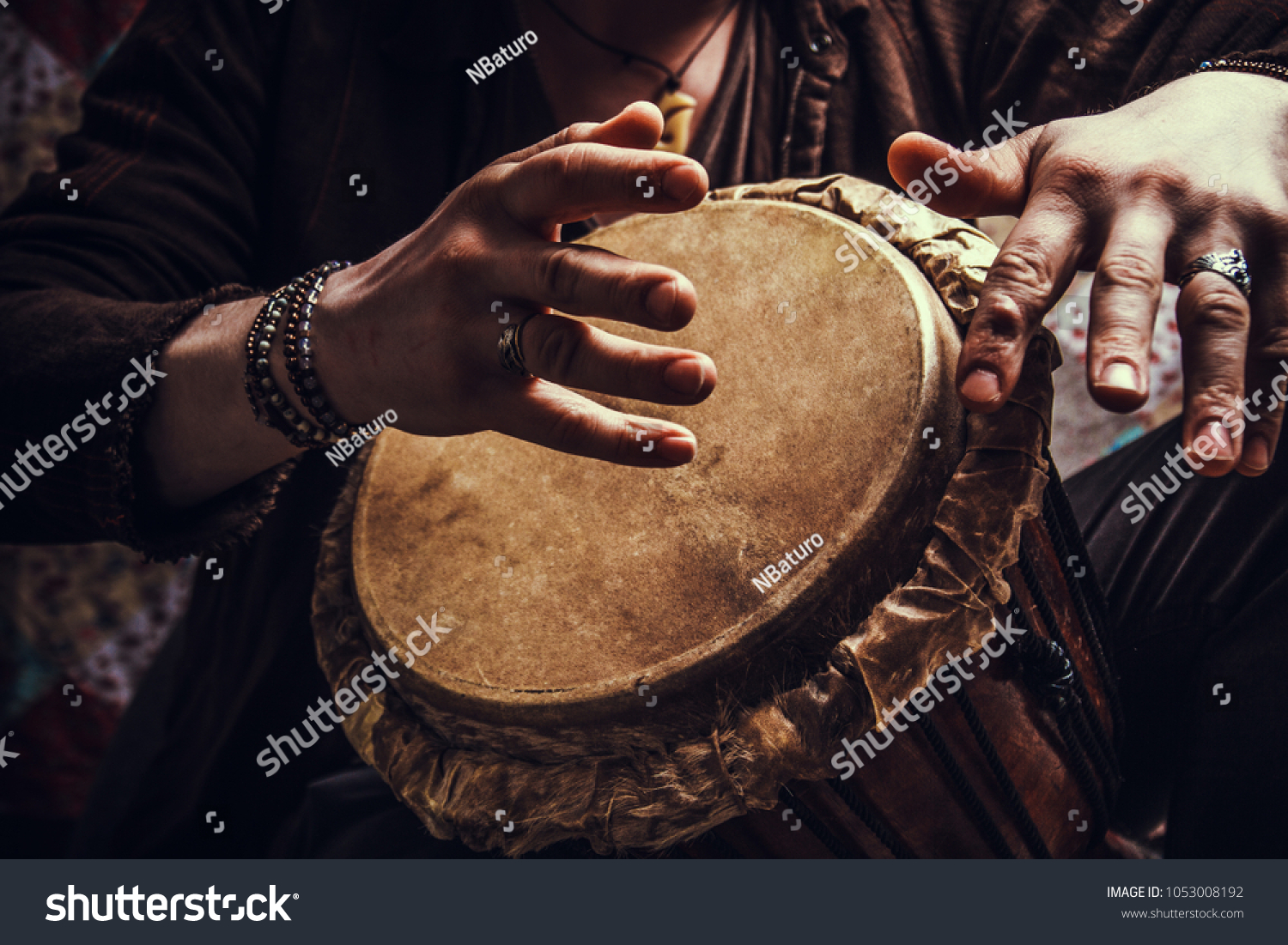 ethnic percussion musical instrument jembe and male hands #1053008192