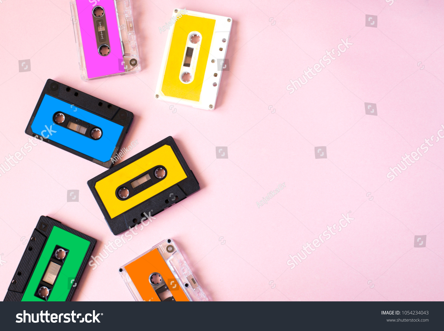 Retro cassette tape collection on pink background, top view, copy space. #1054234043